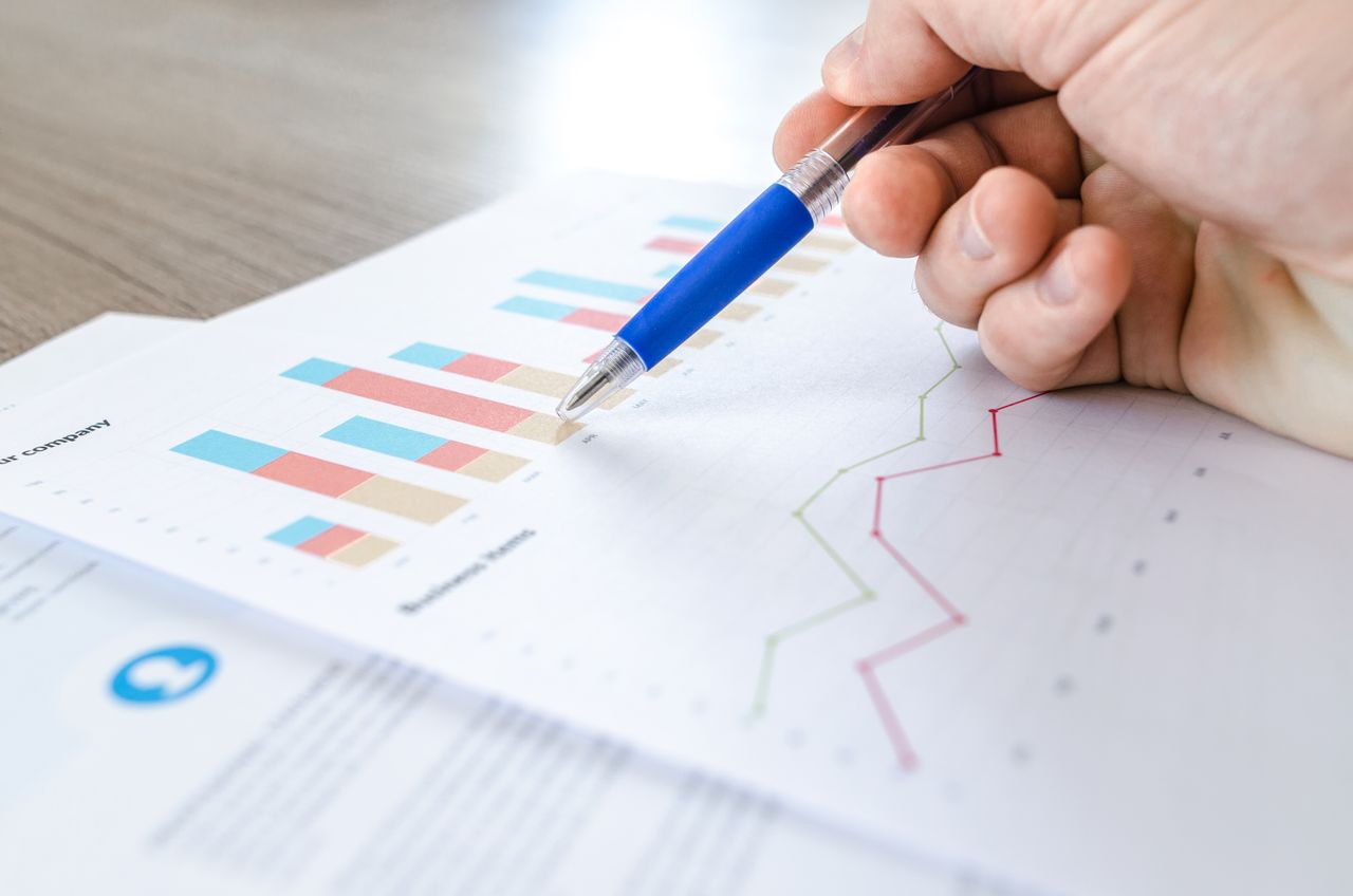 business analyst reviewing market data charts on laptop screen showing growth metrics and financial analysis