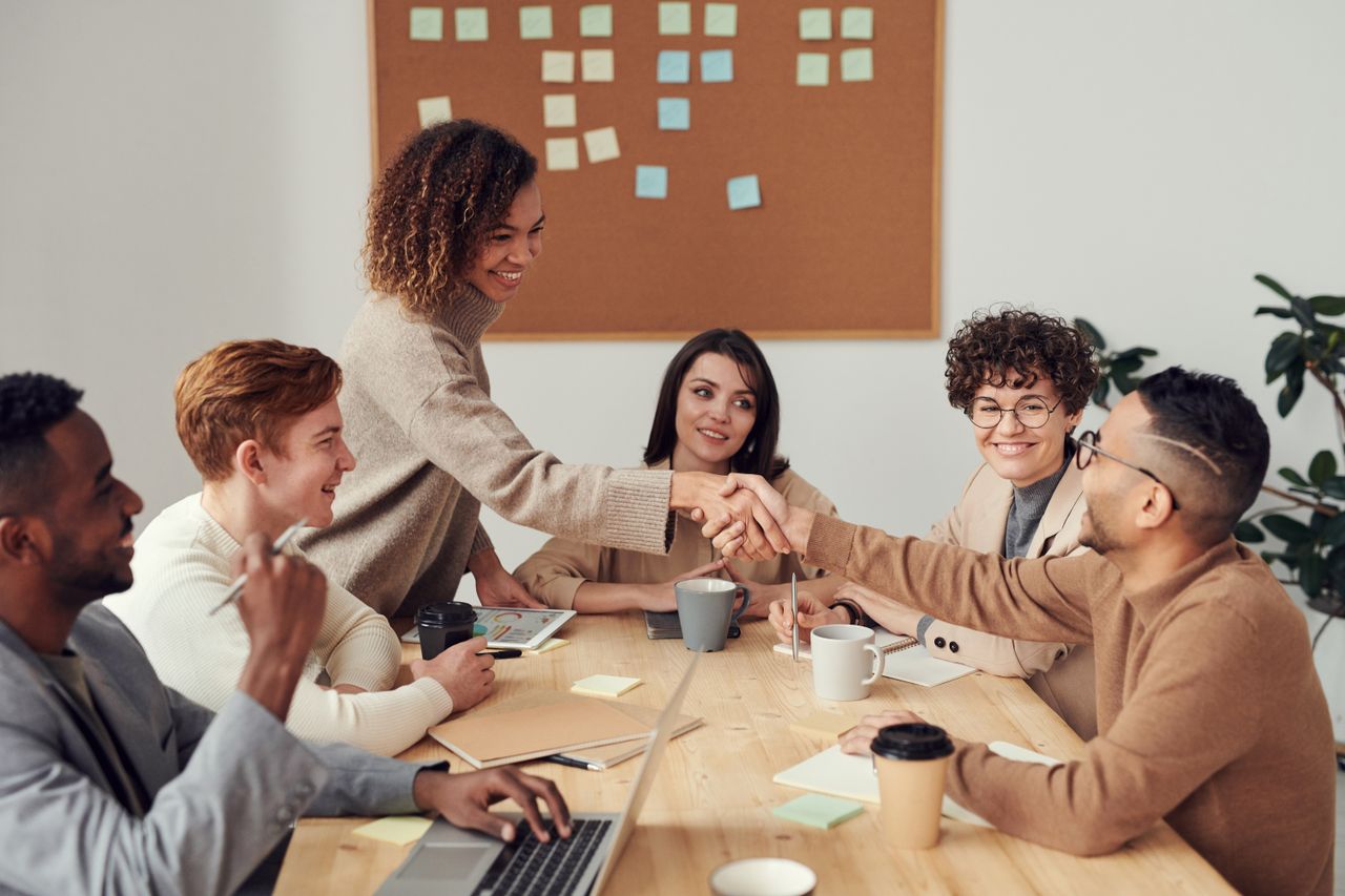 international business team strategizing around conference table with world map projection showing global market expansion