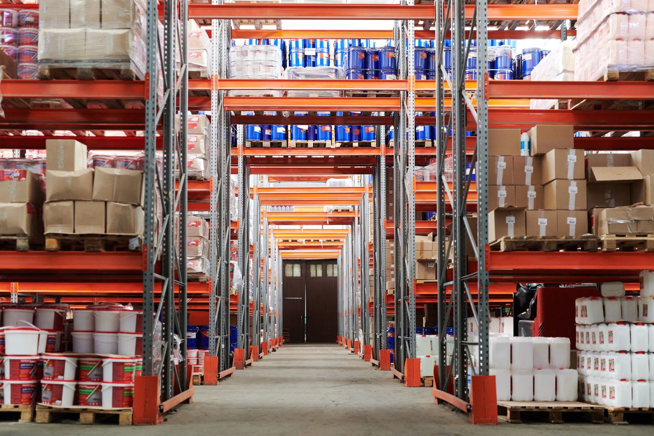 warehouse workers organizing boxes of consumer electronics products on industrial shelving for export