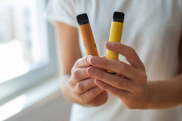 Wholesale buyer inspecting disposable vape devices on retail counter